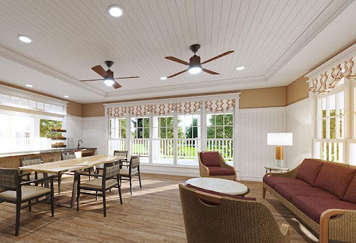 A cozy and well-lit living space featuring a dining table, comfortable seating, and large windows allowing for plenty of natural light.