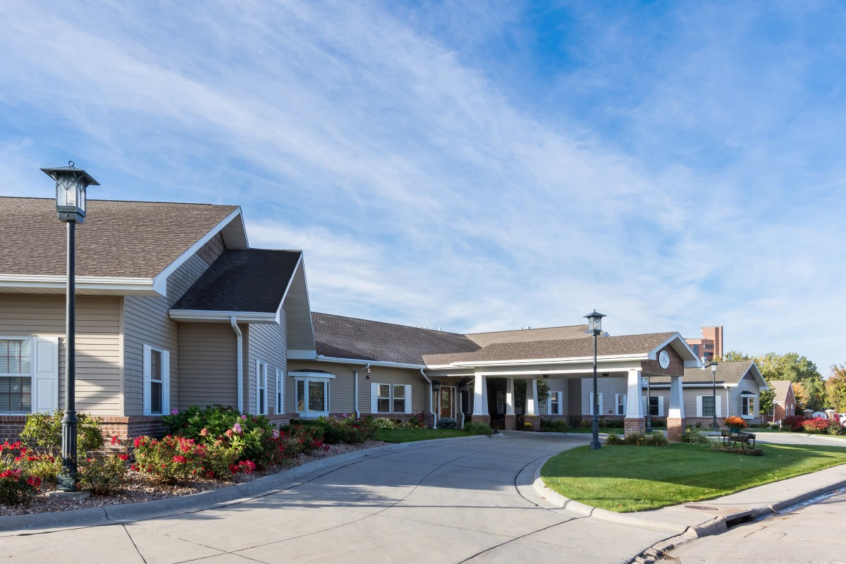 A residential building with a driveway and clear sky.