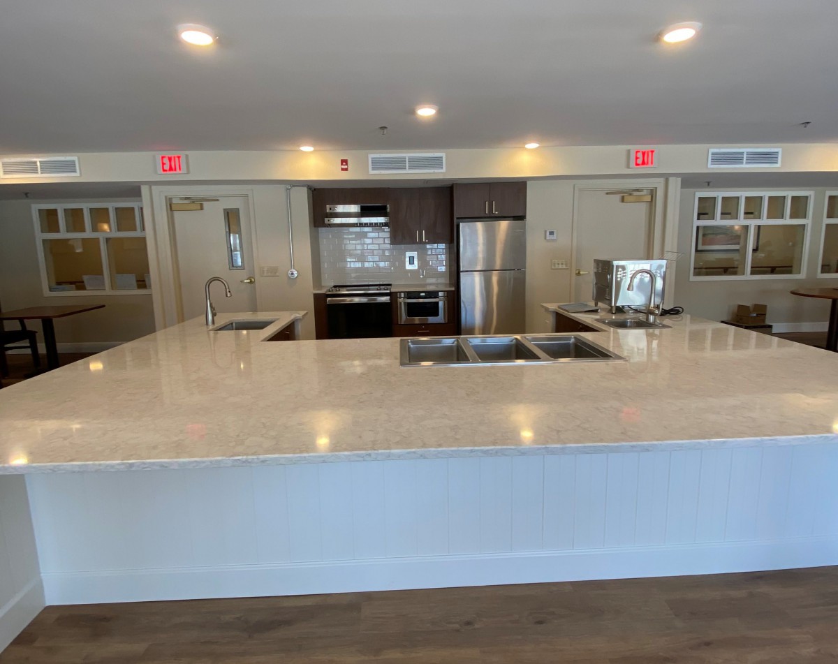 A modern kitchen with a large countertop and stainless steel appliances.