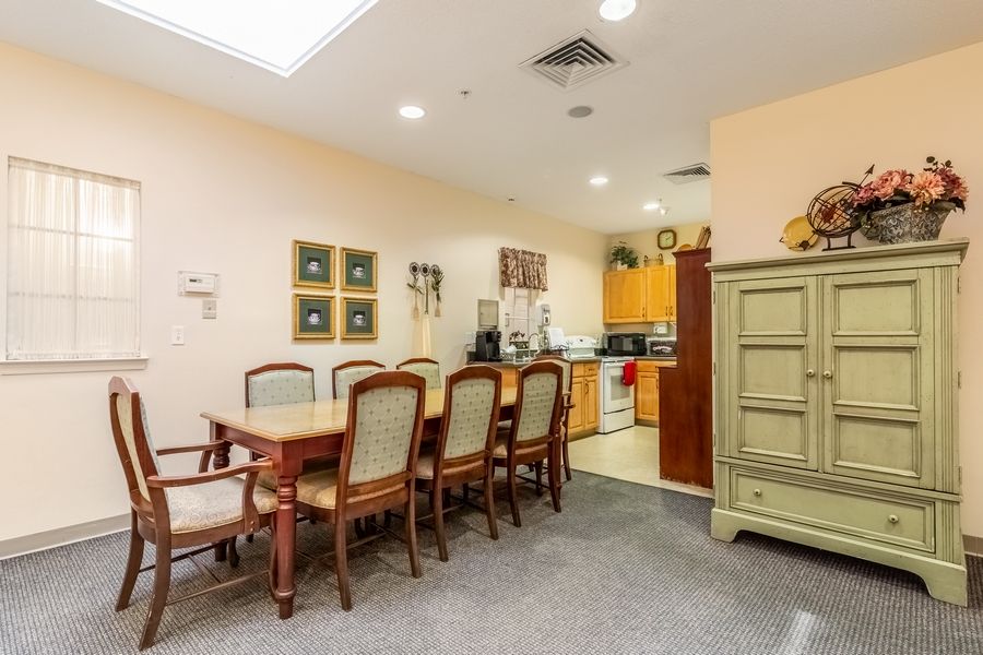 A cozy dining area with a wooden table and chairs, adjacent to a kitchen.