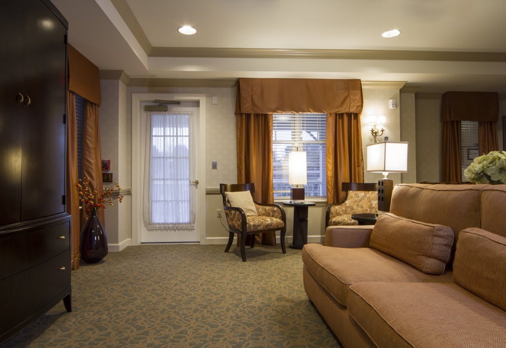 A cozy living room with a sofa, chairs, and warm lighting.