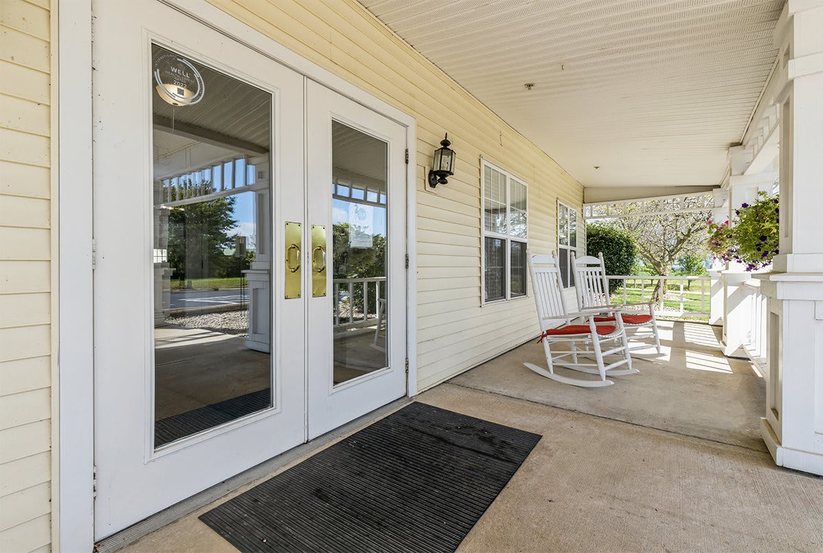 A welcoming front porch with rocking chairs and glass double doors.