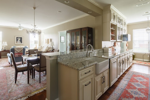 A spacious kitchen featuring a granite countertop that opens up to a cozy dining area.