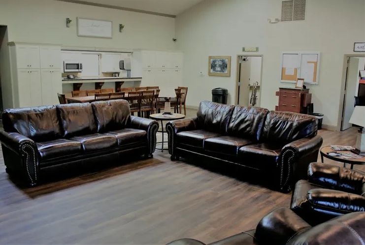 A cozy living room with leather sofas and a wooden floor.