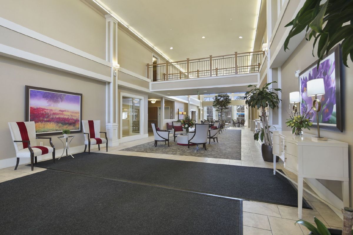 A spacious lobby with elegant seating and decor, featuring a mezzanine and large windows.