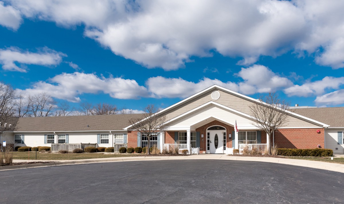 A suburban building with a clear blue sky and scattered clouds.