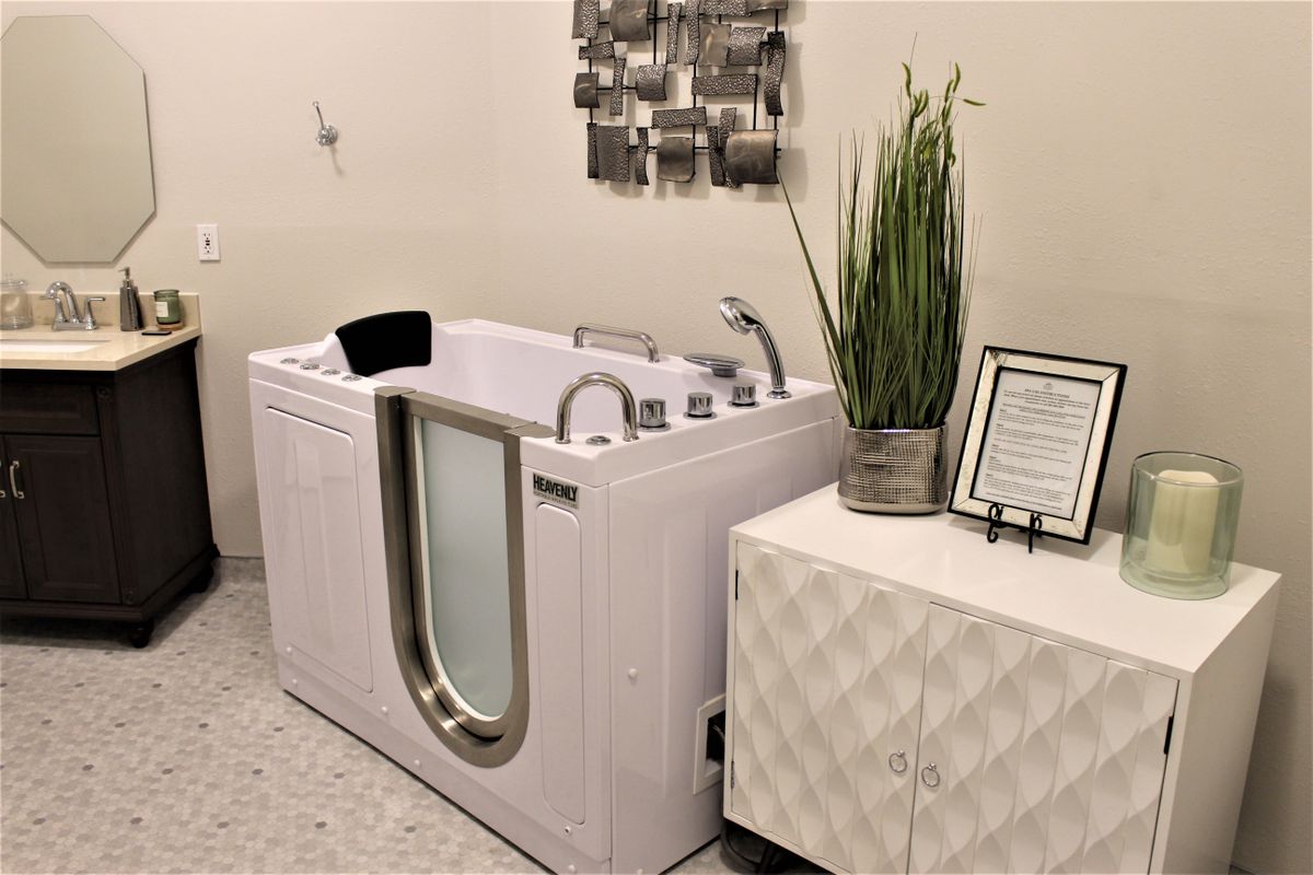 A modern bathroom setup featuring a walk-in bathtub and decorative elements.