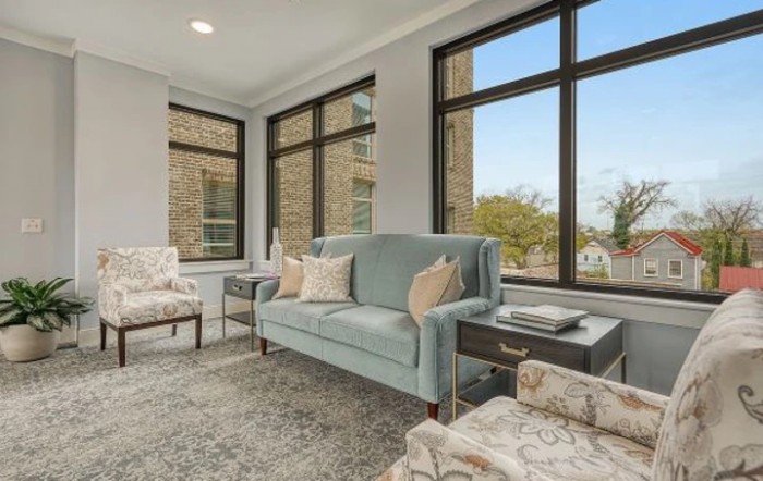 A modern living room with comfortable furniture and large windows.