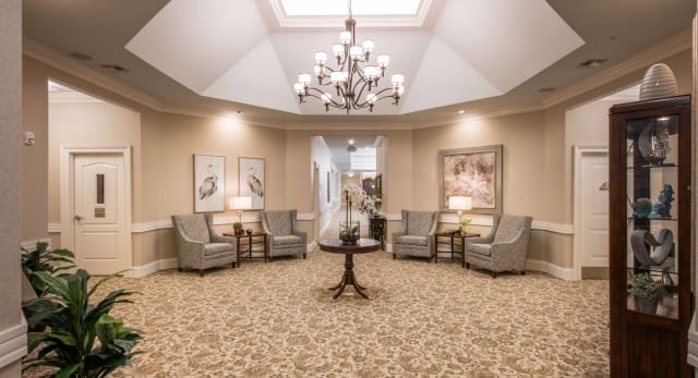 An elegant lobby with a chandelier, comfortable seating, and tasteful decor.