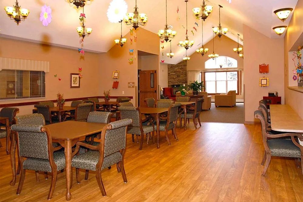 A cozy dining area with elegant chandeliers and wooden flooring.