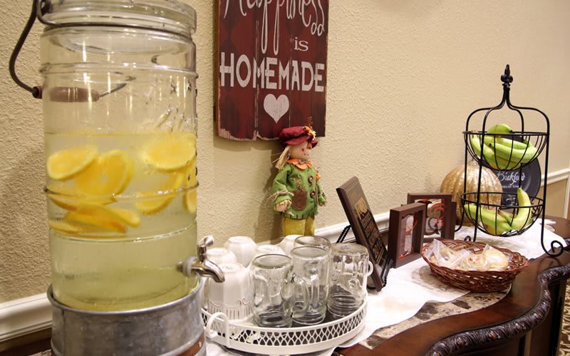 A cozy kitchen setup with a lemonade dispenser and homemade decor.