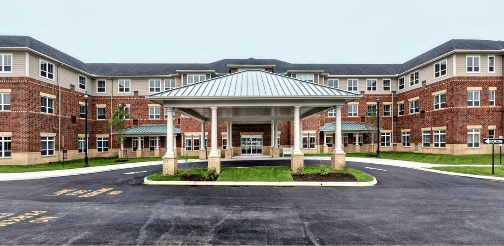 A brick building with a prominent covered entrance and circular driveway.