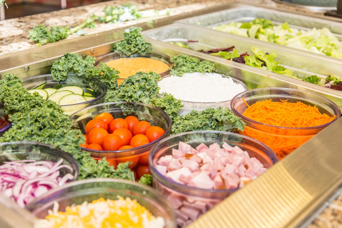 A vibrant salad bar with a variety of fresh vegetables and ingredients.