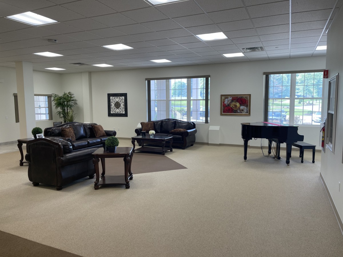 Spacious lounge area with sofas and a piano.