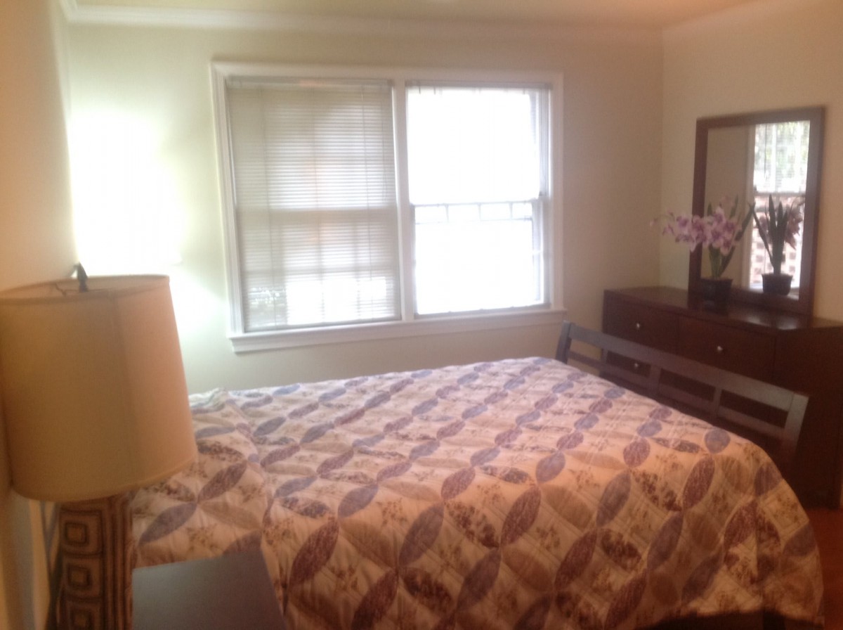 Cozy bedroom with a queen-sized bed and natural light from the window.