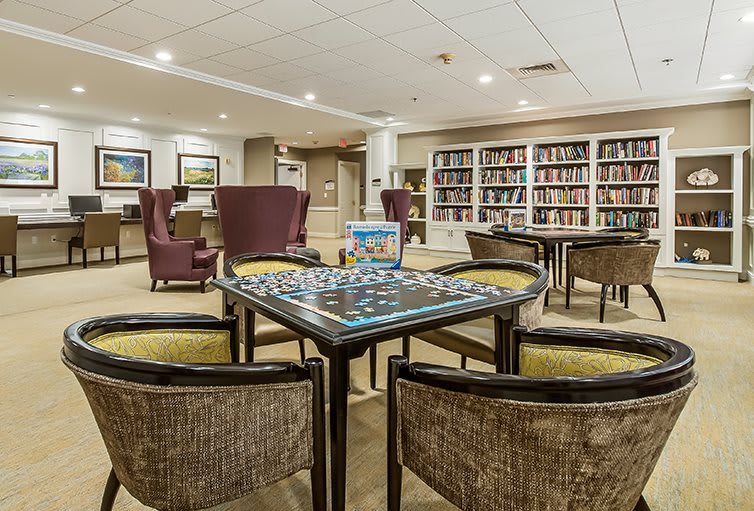 Cozy library with a puzzle on the table surrounded by comfortable seating.