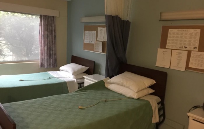 A hospital room with two beds separated by a curtain.