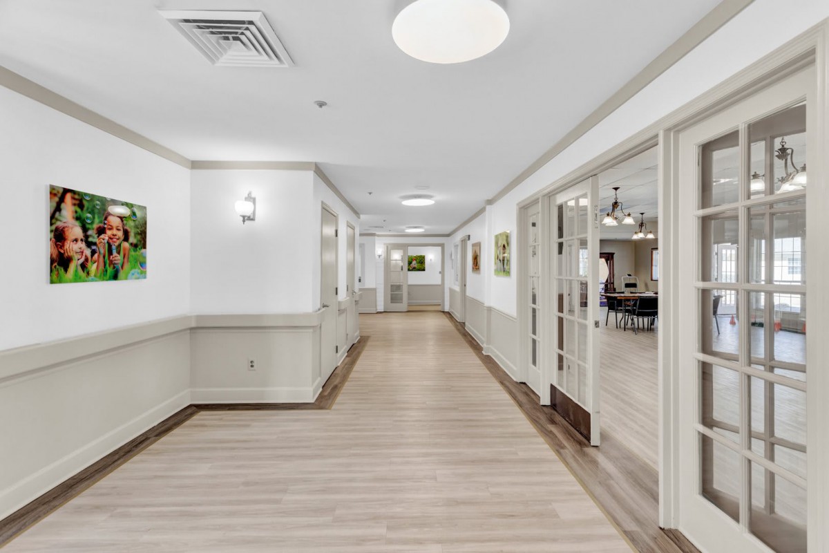 A modern and clean hallway with bright lighting and open doors.