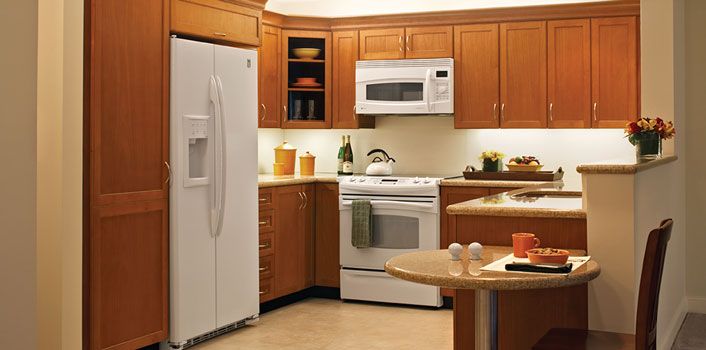 A modern kitchen featuring wooden cabinets and white appliances.