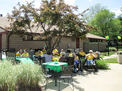 A lively outdoor gathering of senior citizens enjoying the sunshine while wearing matching yellow shirts.