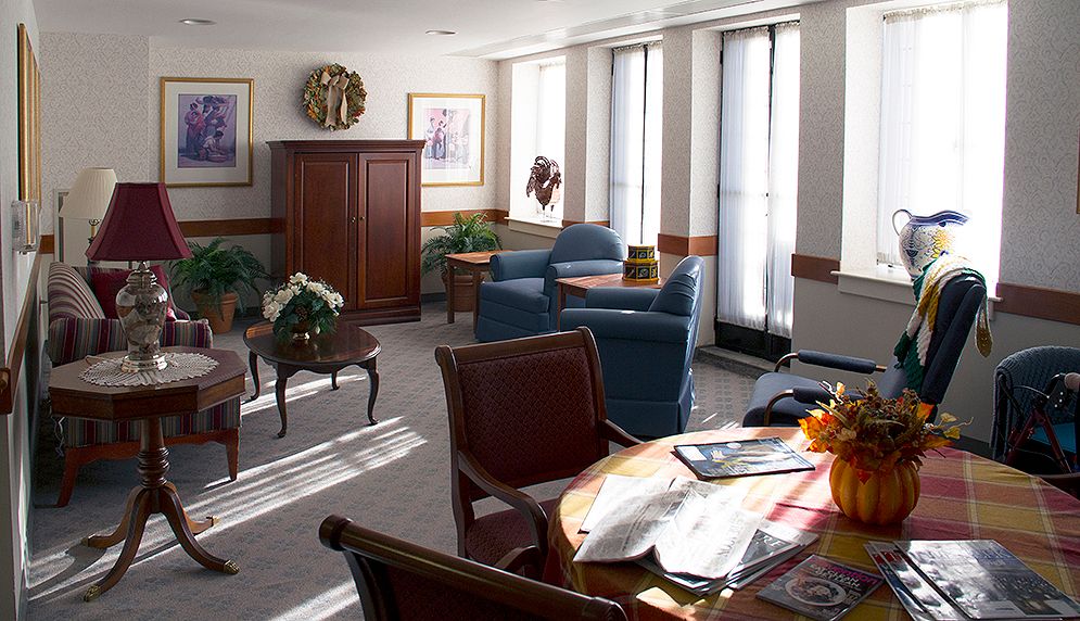 A cozy living room with comfortable seating, a wooden table, and plenty of natural sunlight.