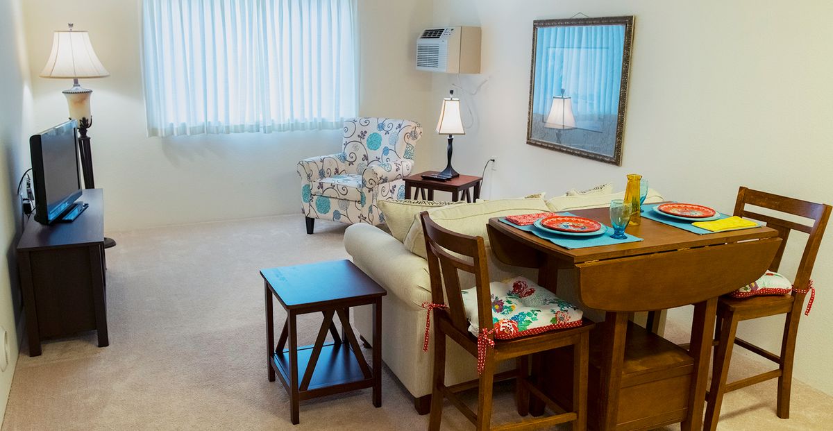 A cozy living room with comfortable seating and a small dining area.