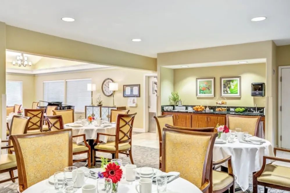 A spacious and elegantly decorated dining room with neatly arranged tables and chairs.