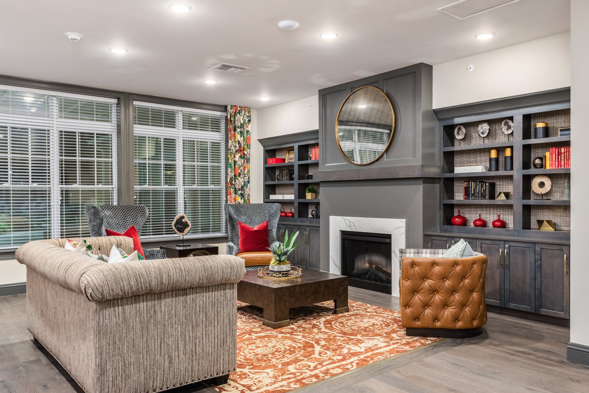 A cozy living room with a modern fireplace, bookshelves, and comfortable seating.