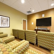 A cozy waiting room with patterned chairs and a television.