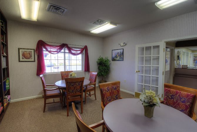 A small meeting room with a round table, chairs, and decorative elements.