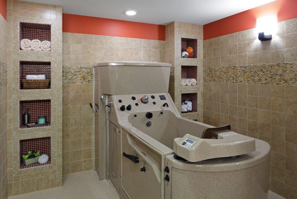 A spa room featuring a therapy tub with tiled walls and shelves.