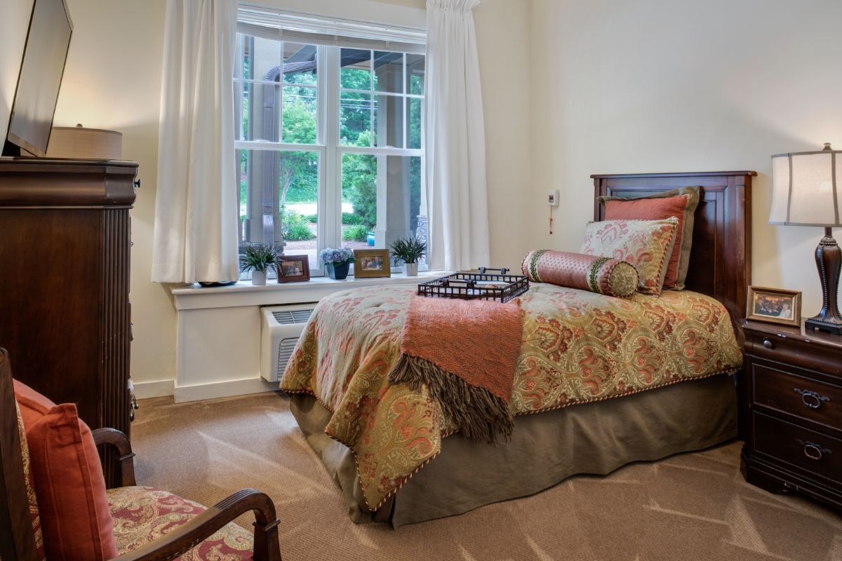 Cozy bedroom with elegant decor and a large window providing natural light.