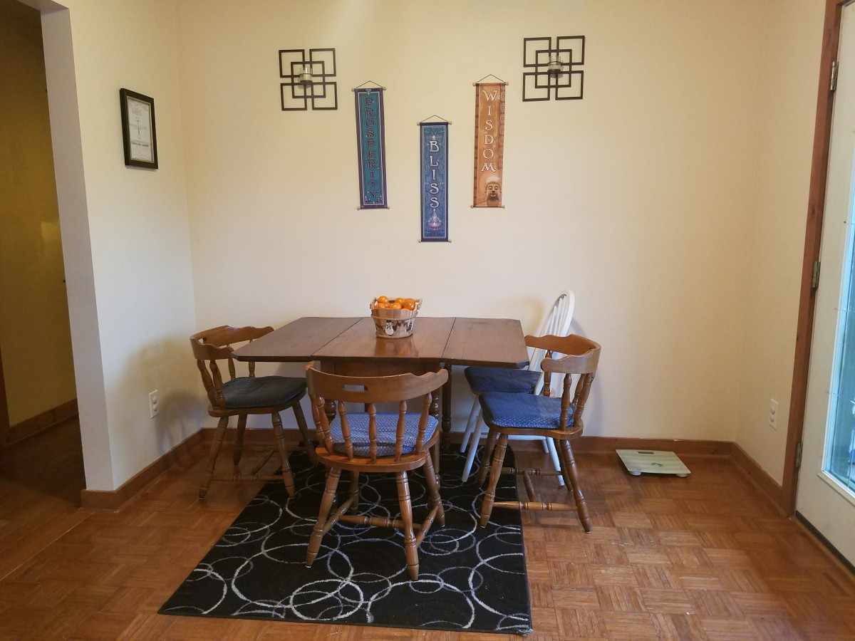 A cozy dining room with a wooden table, chairs, and decorative wall art.