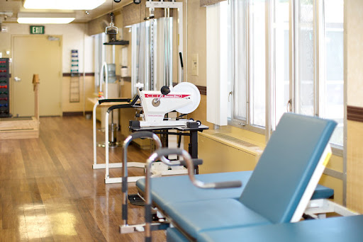 A well-lit physical therapy room featuring various exercise equipment.