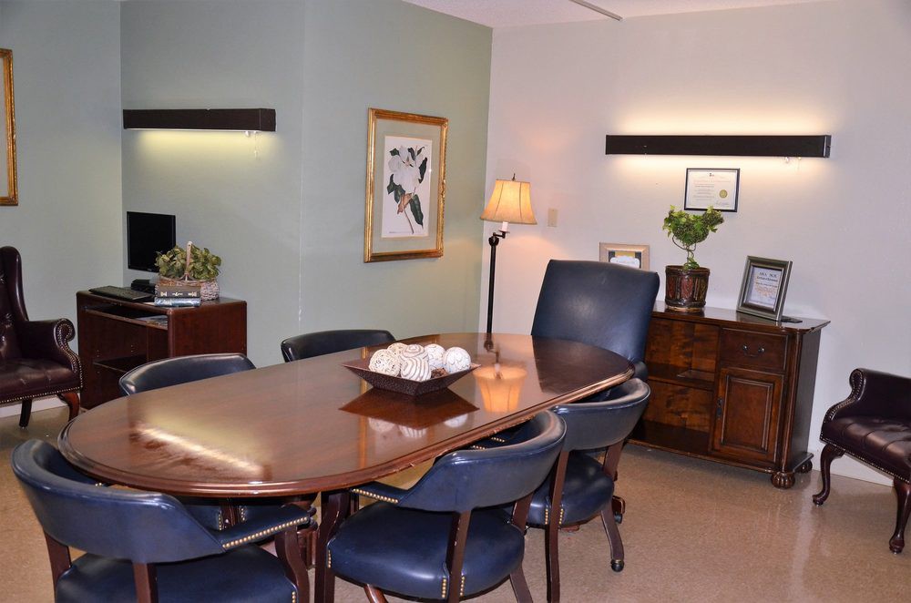 A well-organized conference room with a polished wooden table and leather chairs.