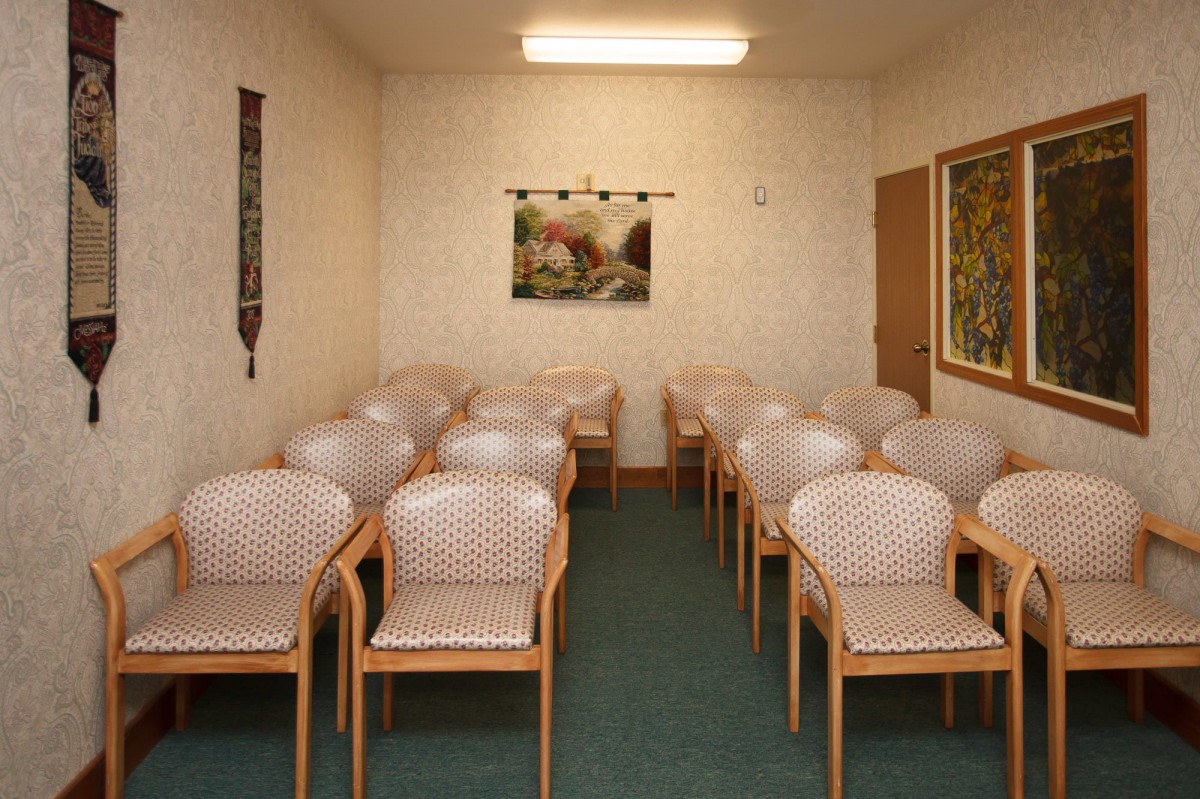 An empty waiting room with neatly arranged chairs.