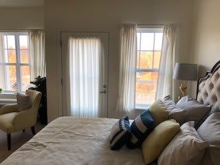 A cozy bedroom with a neatly made bed and soft lighting.