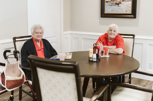 Two seniors enjoying a conversation at a table.