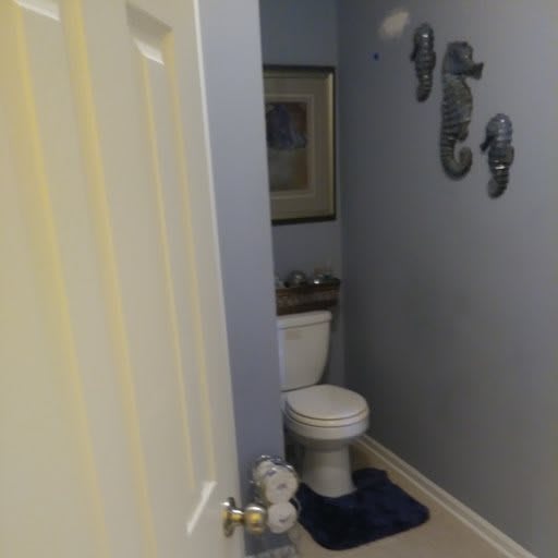 A neatly organized bathroom with wall decorations.