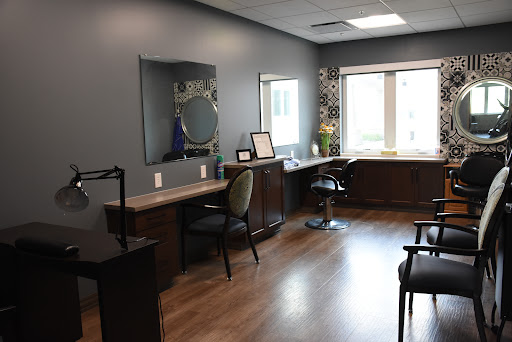 A modern and inviting salon interior featuring sleek furniture and ample natural light.