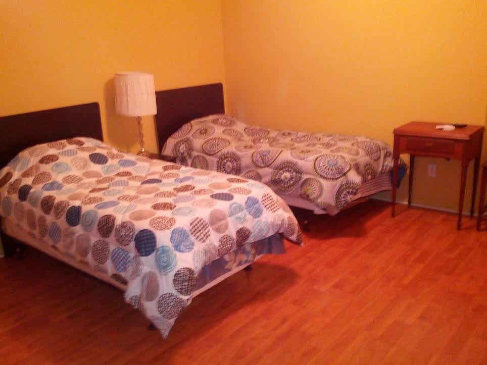 A cozy bedroom with two single beds and a nightstand.