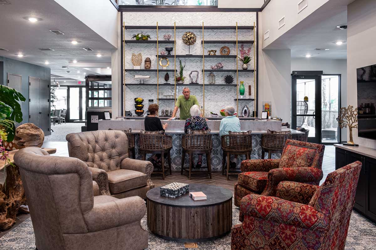 A cozy lounge area with comfortable seating and a small bar, adorned with decorative shelves.