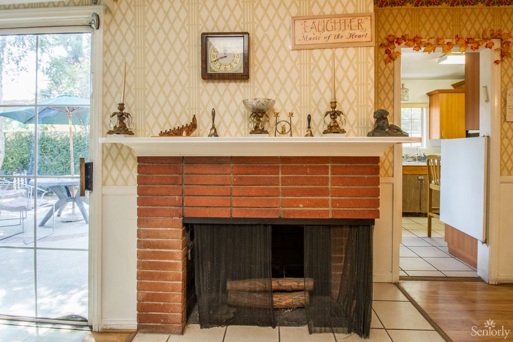 A vintage brick fireplace with a decorated mantel in a cozy home interior.