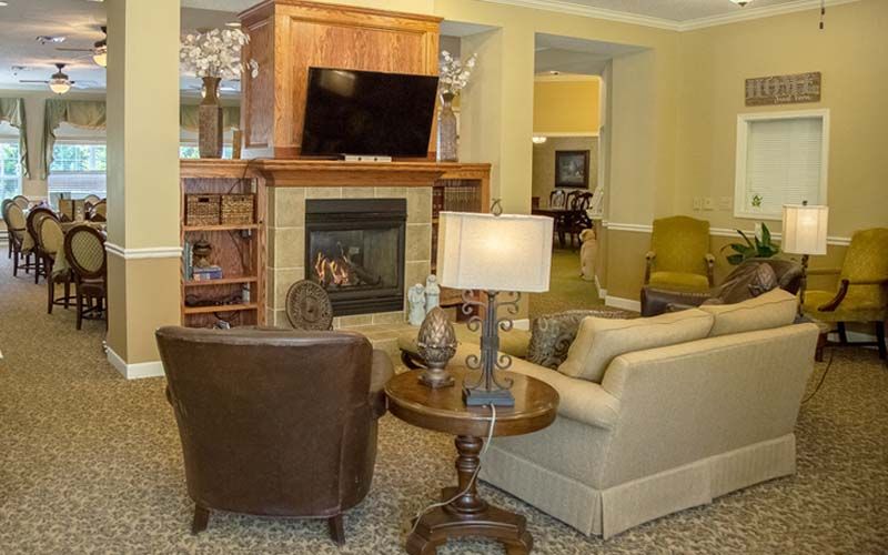 A cozy living room with a fireplace and television, featuring comfortable seating and stylish decor.