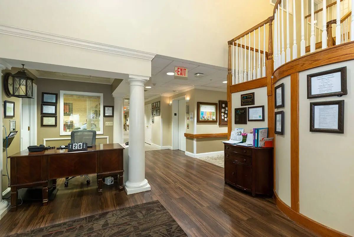 A well-lit office reception area with wood flooring and decorative columns.