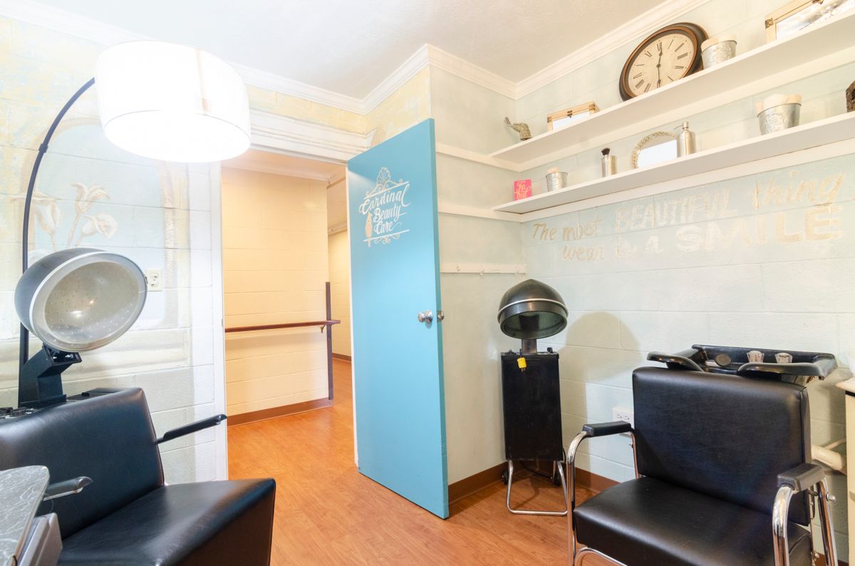 A neatly organized salon interior with styling chairs and hairdressing equipment.