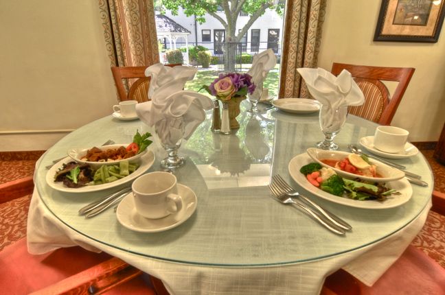 A beautifully set dining table with salads and floral centerpiece.