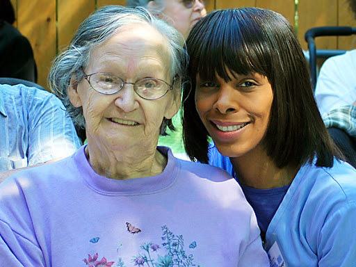 A joyful moment shared between an elderly woman and a younger woman outdoors.