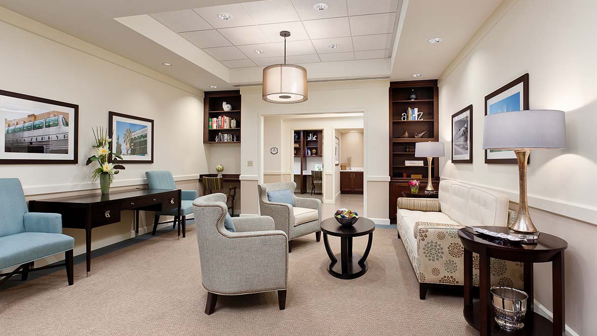 A cozy lounge area with comfortable seating, bookshelves, and a central table.