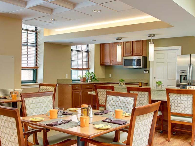 A modern dining area with wooden furniture and a connected kitchen space.